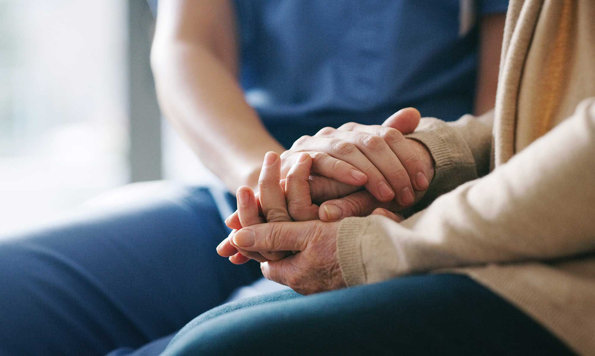 Hände halten eine andere Hand – tröstende Geste